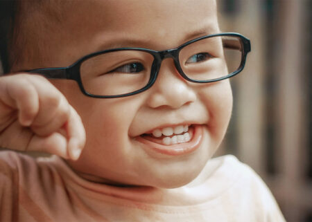 infant smiling wearing glasses